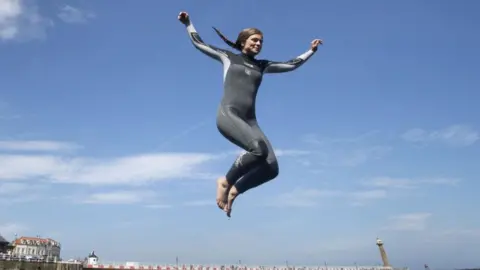 PA Media Woman jumps into sea