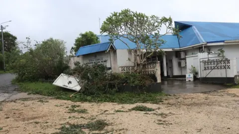 UNICEF Pacific A house sinking into muddy water after being hit by Cyclone Judy