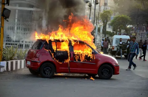 EPA A car burns during a protest against the release of Bollywood movie "Padmavat", in Bhopal on 24 January 2018.