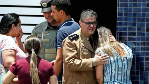 AFP/Getty Police comfort a woman at the scene of the shooting
