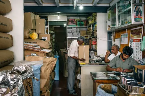 Schmoo Theune Workers work in a tea shop in Kandy