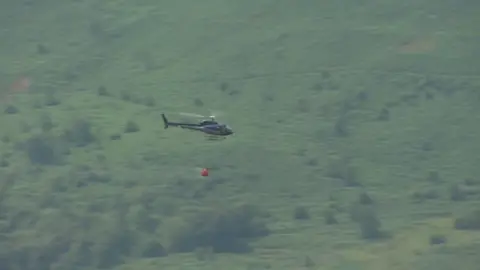 Helicopter flying over mountains in Twmbarlwm