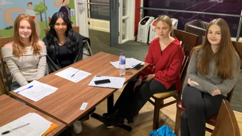 Four girls sitting around a table