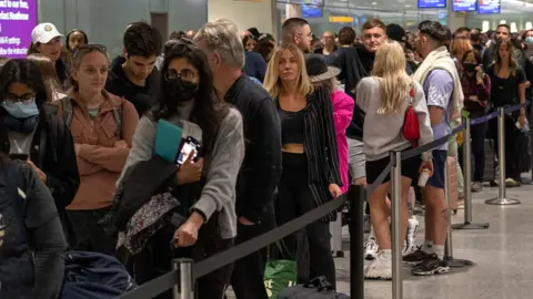 Getty Images People queue at Heathrow airport