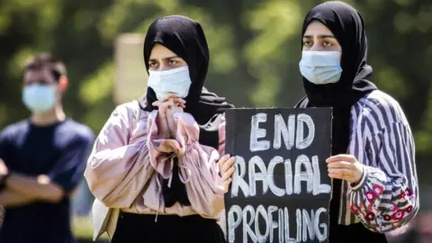 EPA Veiled women hold a placard as supporters and members of the Dutch action group "Kick Out Zwarte Piet" (KOZP) from The Hague stage their second demonstration this month at the Malieveld in The Hague