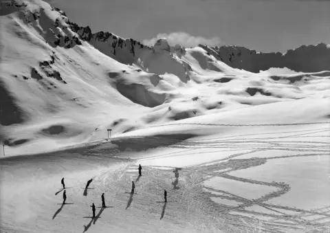 Roger Viollet / Getty Images Skiers at a mountain pass, after the war (1952)