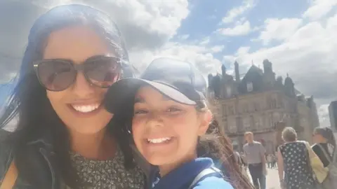 Family handout A mother and child smiling in front of Birmingham council house