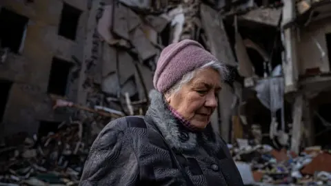 Getty Images A woman looks at the buildings she used to live in until they were destroyed by a Russian rocket attack in Kramatorsk, Ukraine