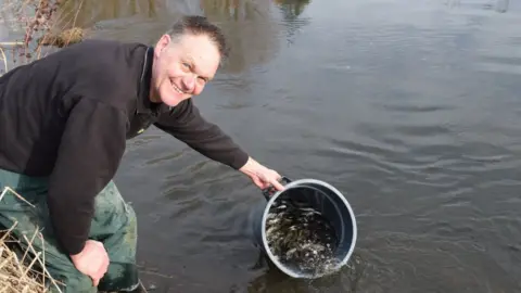 Environment Agency Paul Frear releases fish