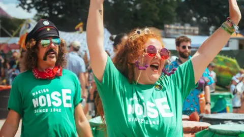 Longtime Oxfam campaigners, Alan Shaw and Summer Dean, enjoy a sing and a dance at Glastonbury 2023