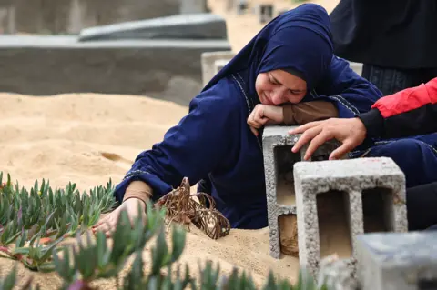 AFP A woman cries over the grave of a loved one at the start of the Eid al-Fitr festival, marking the end of the Muslim holy month of Ramadan, at a cemetary in Rafah in the southern Gaza Strip, on 10 April 2024