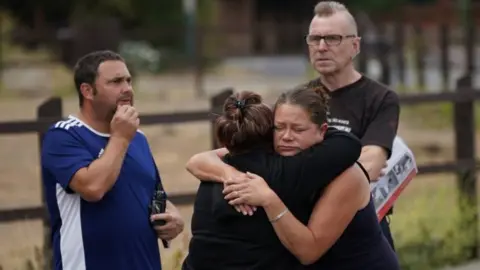 PA Media Residents of Wennington hugging each other