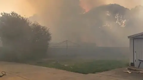 Reuters/Chirag Thakkar Thick smoke from a bushfire engulfs a yard in Adelaide