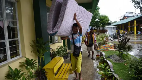 AFP/Getty A resident carries a matress inside a classroom used as an evacuation centre as Typhoon Mangkhut approached the city of Tuguegarao