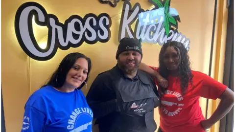 BBC Cross Kitchenn and Trade The Blade founder Odane Cross with Ambassadors Jordan Turner to his left and Danyelle King on his right from the charity Change Lives No To Knives
