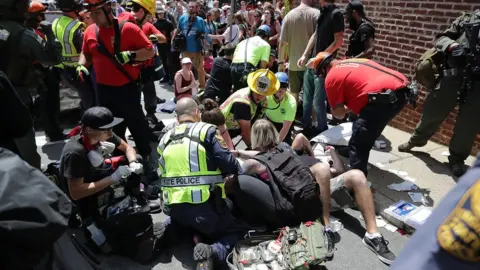 Getty Images Emergency services treat the injured after a car drove into anti-fascist demonstrators in Charlottesville