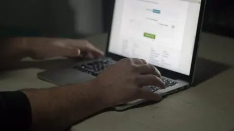 Getty Images A man's hands at a lap top