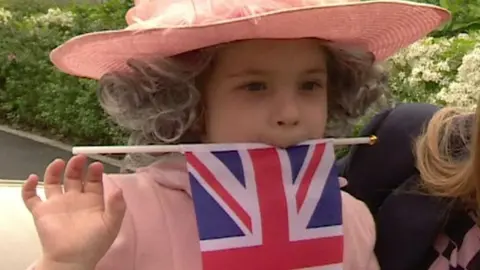 Young girl dressed up as the queen with a union jack flag