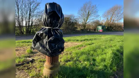 The stink pipe stump, covered with a black bin liner