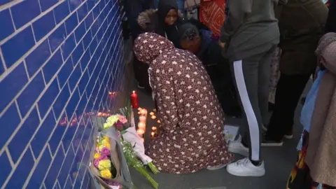 Mourners laid flowers and candles