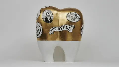 Kazz Morohashi The gold plated tooth represents the kindness of a dentist monk