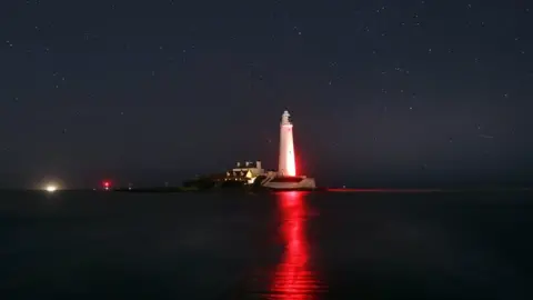 PA St Mary's Lighthouse, Whitley Bay, glows red in honour of the centenary