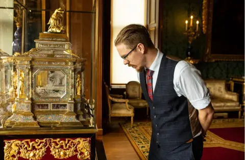 Antonio Olmos Fjodor looks at the casket of the an organ clock