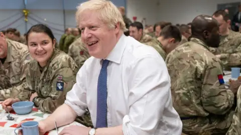 Getty Images Britain"s Prime Minister Boris Johnson meets British troops stationed in Estonia for a meal at the Tapa military base