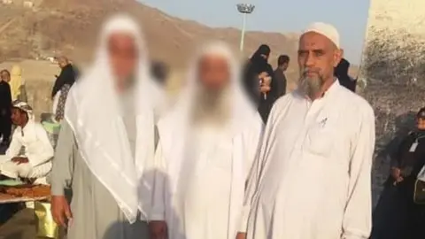 Supplied Mr Khan (right) seen during his pilgrimage with two others