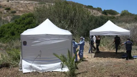 PA Media Forensic police officers prepare to examine an area of wasteland to search for Madeleine McCann in the town of Praia da Luz, Portugal