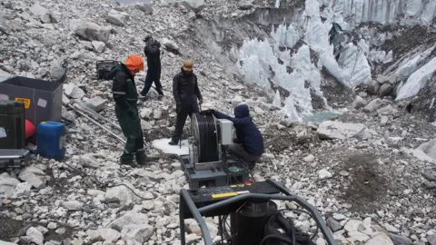 Prof Bryn Hubbard / Aberystwyth University The team drill into the glacier