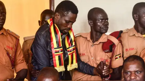 Getty Images Uganda's prominent opposition politician Robert Kyagulanyi known as Bobi Wine (C) appears at the chief magistrate court in Gulu, northern Uganda, on August 23, 2018