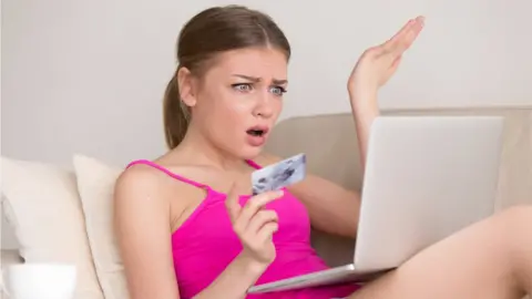 Getty Images Young woman with lap top and card