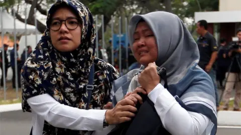 Reuters Two emotional women arrive at Soekarno Hatta International airport near Jakarta