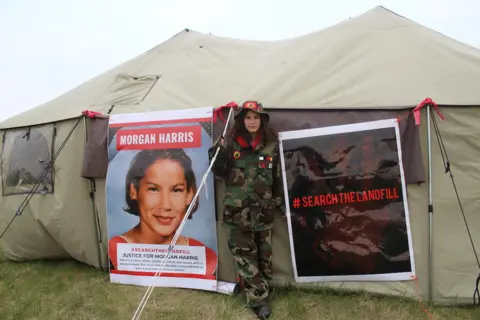 Brandi Morin Cambria at the landfill search tent near a photo of her mother