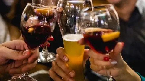 Getty Images Drinking in a bar with friends