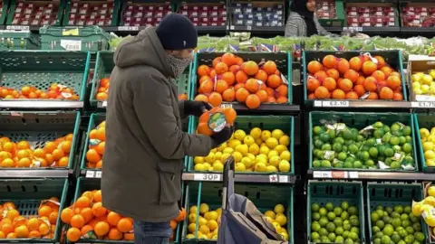 Getty Images Man looking at fruit in a Tesco supermarket