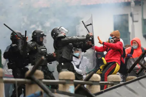 Luisa Gonzalez / Reuters Demonstrators clash with members of security forces during a protest against tax reforms in Bogotá, Colombia, on 28 April 2021