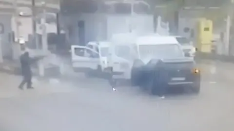 Armed men approaching a prison van