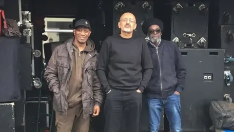 Ashish Joshi Ashish Joshi (centre) with Norton Stewart 'Snoopy' (left) and Maurice Gayle 'Skyjuice' (right)