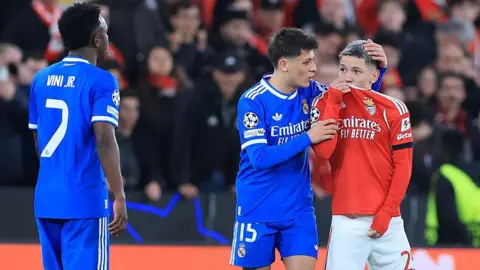 SL Benfica's Argentine forward Gianluca Prestianni hides his mouth while arguing with Real Madrid's Brazilian forward Vinicius Junior