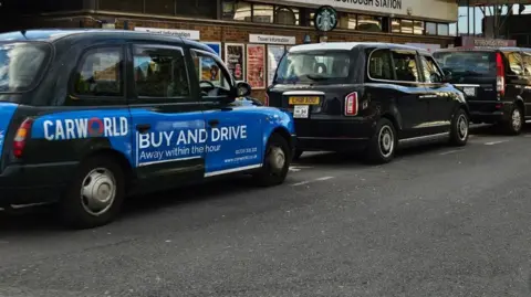 Row of black taxis outside the train station