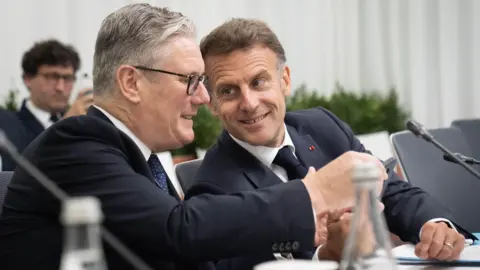 PA French President Emmanuel Macron shows British Prime Minister something on his phone during the European Political Community summit in Yerevan, Armenia. 