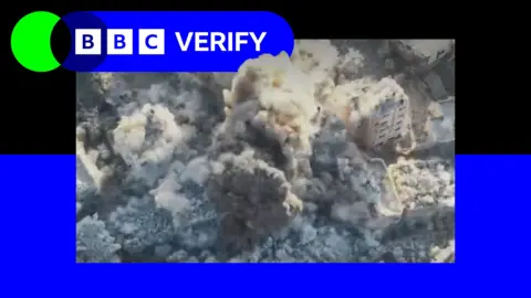 X A screengrab from a video showing the demolition of a building in Gaza City. Smoke is seen erupting from several buildings as explosives are detonated. The image is imposed over the BBC Verify colours and branding. 
