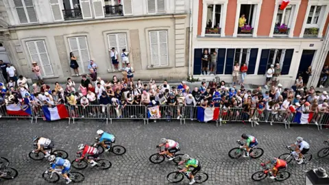 Getty Images Ludzie wspinają się na parapety okienne, aby oglądać kolarzy podczas Igrzysk Olimpijskich w Paryżu