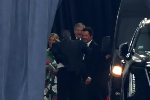 Reuters US TV presente Jimmy Fallon arrives at Madison Square Garden behind a dark curtain.