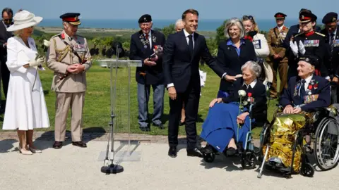 LUDOVIC MARIN/POOL/AFP France's President Emmanuel Macron (C) reacts after awarding 104-years-old British World War II veteran, Christian Lamb (2ndR), who helped to plan the D-Day landings in Normandy, with the insignia of Knight in the Legion of Honour order, as Britain's Queen Camilla (L) and Britain's King Charles III (2ndL) look on