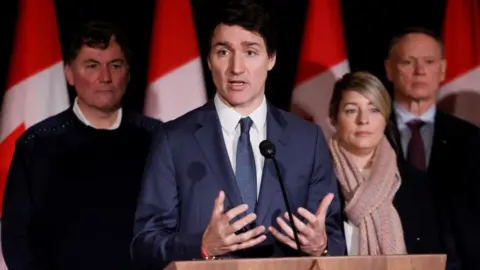 Canada's Prime Minister Justin Trudeau, with Finance Minister Dominic LeBlanc, Minister of Foreign Affairs Melanie Joly, and Minister of Public Safety David McGuinty, takes part in a press conference during a Liberal Cabinet Retreat in Montebello, Quebec, Canada January 21, 2025.