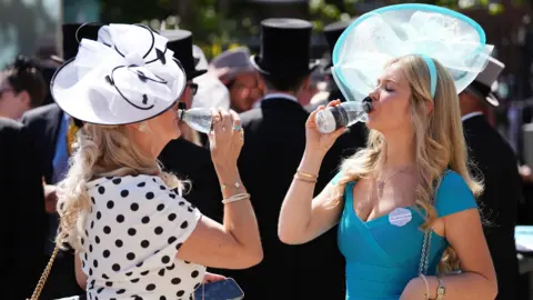 PA Media Racegoers drink water on day four of Royal Ascot at Ascot Racecourse, Berkshire.