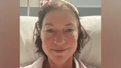 Jo Fuller/Brain Tumour Research/PA Wire Jo sitting up in a hospital bed in Australia